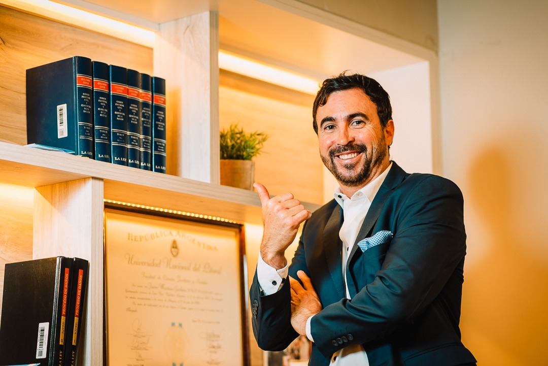 Fernando junto a los libros de derecho y su diploma universitario